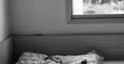 grayscale photo of person lying on bed